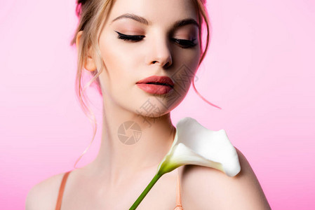 美貌优雅的金发美女拿着花朵在粉红图片