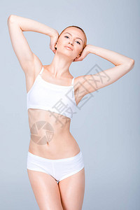 身穿白内裤的年轻漂亮的瘦女人冒着双手顶着头套在图片