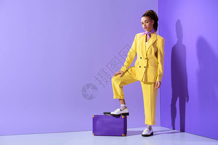 穿着黄色西装和紫色手提箱图片