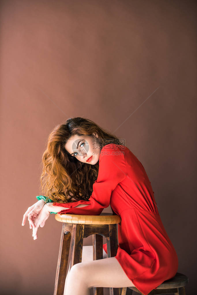 长发红的女人坐在椅子上坐着凳子被图片
