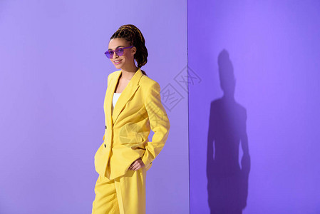 穿着黄色西装和紫色太阳镜穿紫外线背景的紫图片