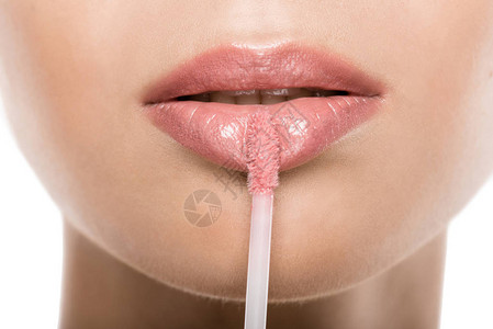 近视美貌丽的女人在嘴唇上用粉红色的唇膏图片