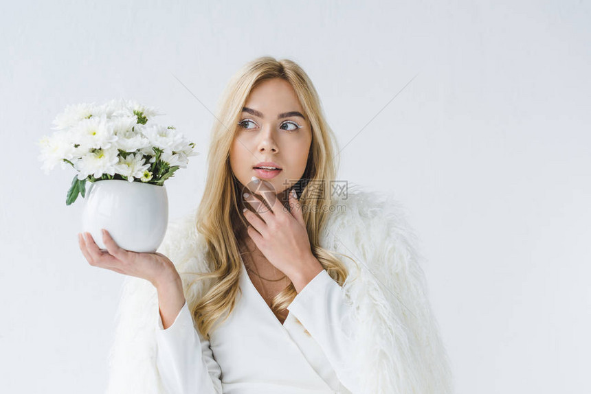 穿着毛皮大衣的时髦粉丝式女人拿着白花图片