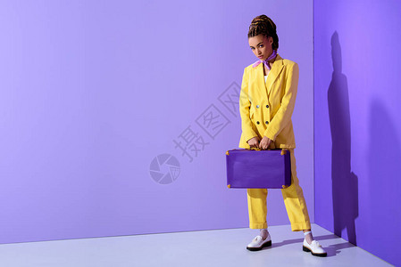 穿紫色手提箱的黄色时装身着潮黄色西装的图片