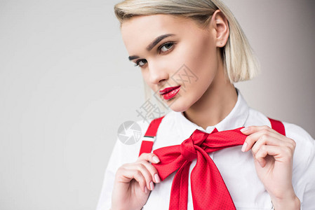 穿着白衬衫红色吊带和蝴蝶结的时尚女孩背景图片