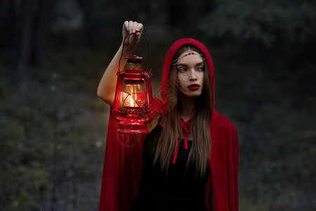 优雅的神秘女孩在黑暗森林中行背景图片