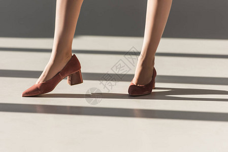 穿着红鞋摆姿势的时尚女孩的低款图片