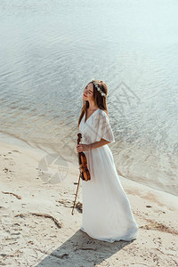 穿着白裙子的漂亮优雅女孩在海滩图片