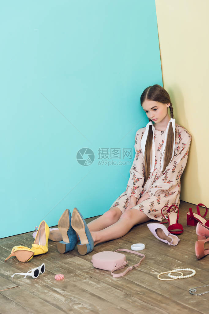 心烦意乱的时尚少女坐在地板上一团糟图片