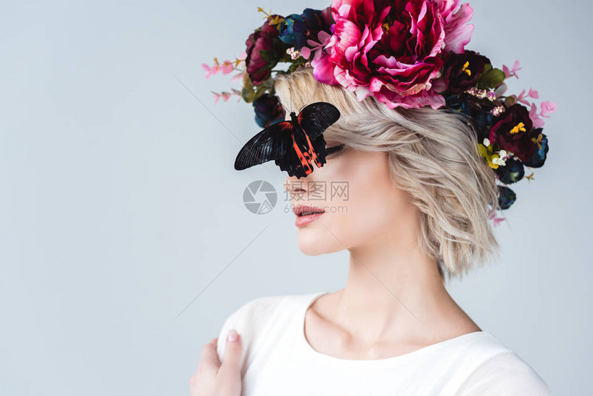 时尚的姑娘穿着花环脸上有美丽的活蝴蝶图片