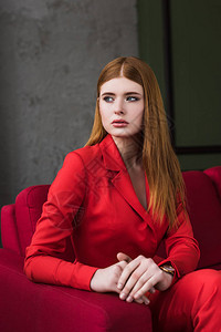 戴着手表的时尚年轻女子身着红色西装背景图片