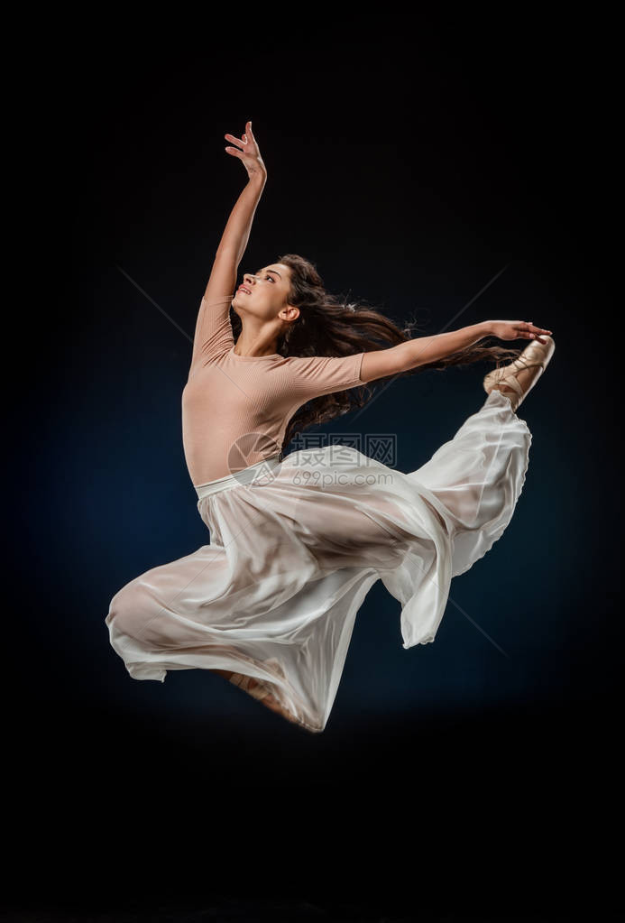 穿着优雅衣服的年轻芭蕾舞女郎在黑图片