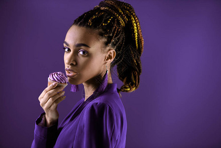 有吸引力的非裔美国女孩穿着时髦紫外特紫外夹克和纸杯蛋糕在图片