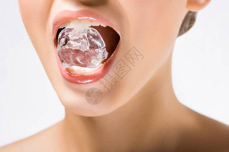 年轻女子嘴里拿着冰块与白色隔离背景图片