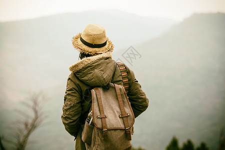 年轻的时髦女人背着包在山上旅行图片