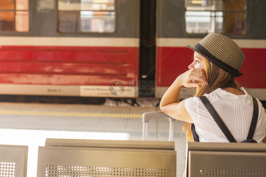 年轻可爱的小女孩在火车站等火车图片