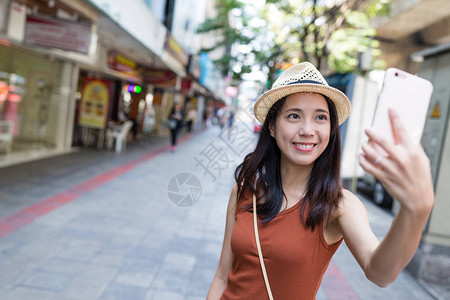 曼谷街头用手机自拍的女人图片