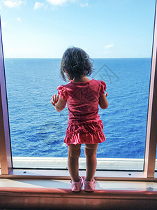 婴儿从一个大船窗望向大海图片