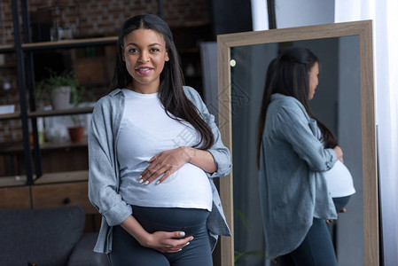 美籍非洲孕妇大肚子站在镜子边图片