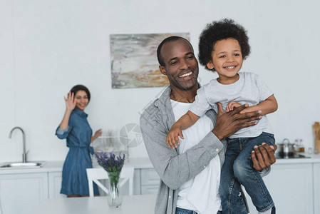 African美洲父亲拥抱儿子和母图片