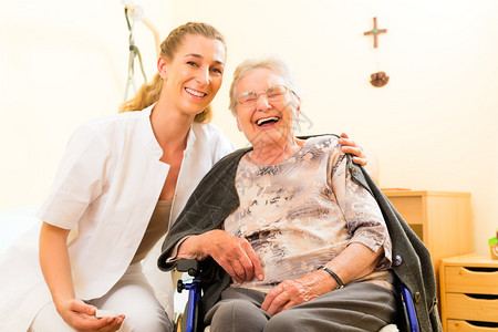 年幼护士和在疗养院的老年女护士坐在轮图片