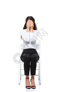 穿着白衬衫的漂亮女商人坐在椅子上用手捂住脸高清图片