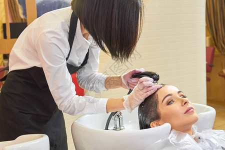正在洗头的女人美容师冲洗染发剂图片