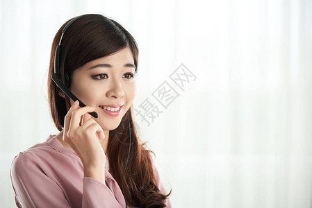 服务台咨询人使用头耳机与客户交谈的图片