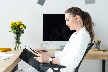 重点突出的女商人在办公室工作场所阅读图片