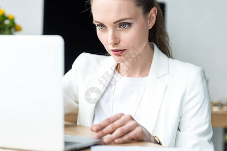 在办公室工作场所从事笔记本电脑工作的有重点的女企业主有图片