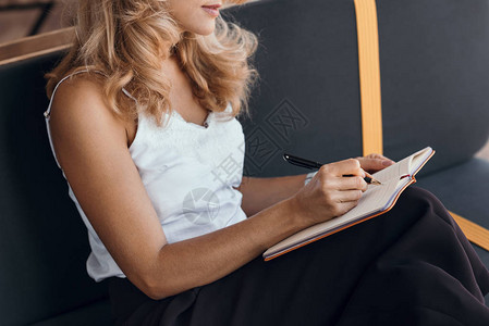 金发中年妇女在笔记本上写字的短片图片