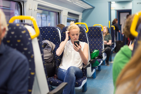 乘坐火车旅行时女在智能手机上工作图片