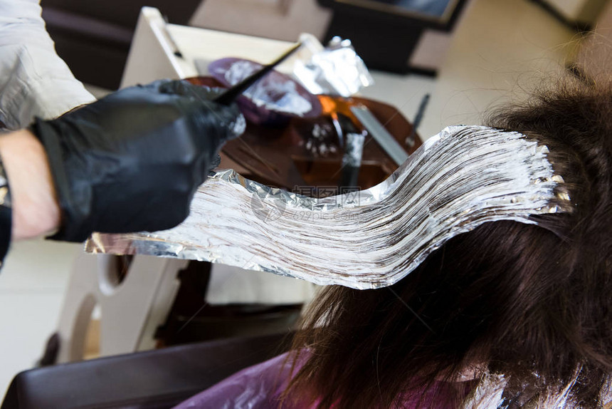 专业理发师染发她客户的头发仔细观察临图片