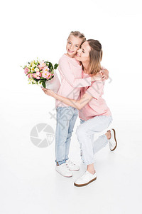 母亲和女儿拥抱并拿着花束给母亲一天在白图片