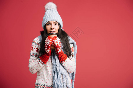 戴冬帽围巾和手套的寒冷妇女拿着咖啡去图片
