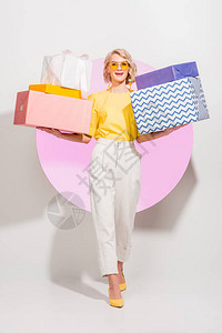 美丽的时装女孩拿着礼物盒带着粉色圆圈图片