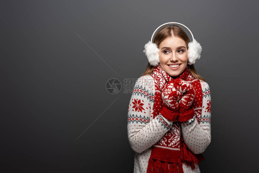 穿着圣诞毛衣围巾手套和耳膜的微笑着微笑的女孩图片
