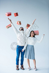 多元文化的一对夫妇捕捉着掉落的包裹着的圣诞节呈现着图片