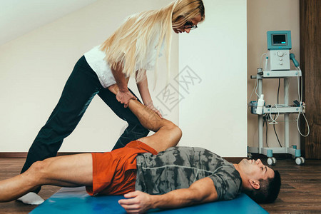 物理治疗师伸展病人的腿图片