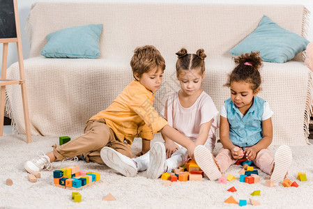 可爱的小种族儿童玩花样多彩的立方体图片