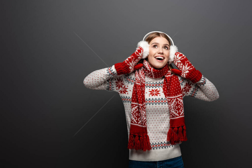 穿着圣诞毛衣围巾手套和耳膜的美丽女士图片