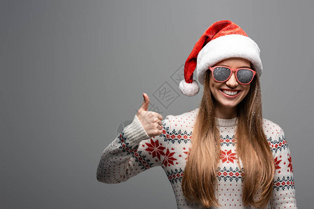穿着圣诞毛衣圣塔帽和太阳眼镜的漂亮正女人图片