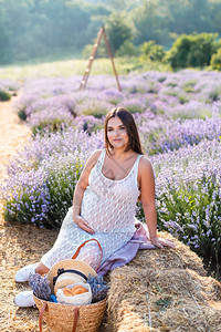 孕妇坐在紫衣草地干枯叶子图片