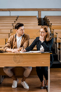 沉思的女教师在课堂上摸下巴检查男学图片