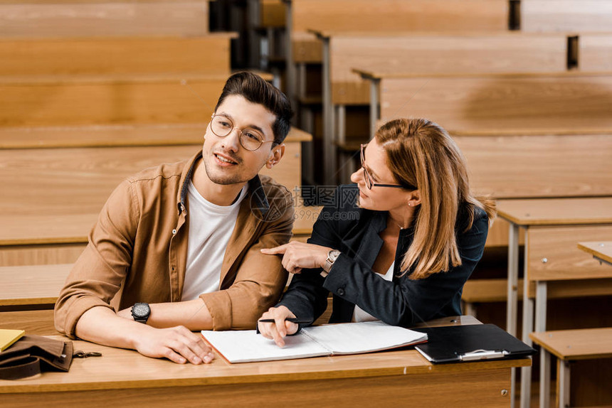 女大学女教师在课堂考试期间与男学生一起坐在书图片