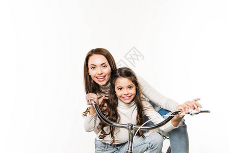 母亲和女儿带着自行车微笑着看着被白色图片