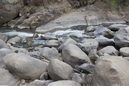 流过森林小溪中石头的水流背景图片