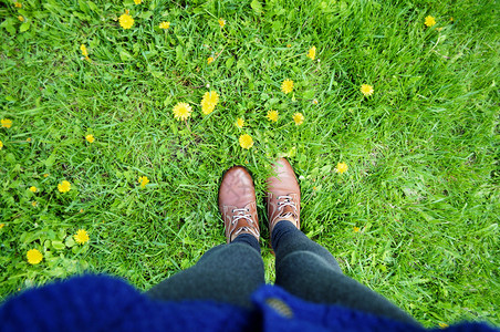 草背景上的靴子脚绿地中的女靴图片