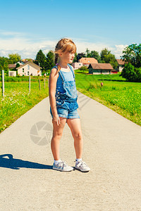 一个6岁小女孩的夏天肖像穿着牛仔服和灰色图片