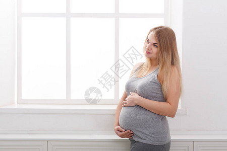 年轻快乐的孕妇想着她的孩子图片